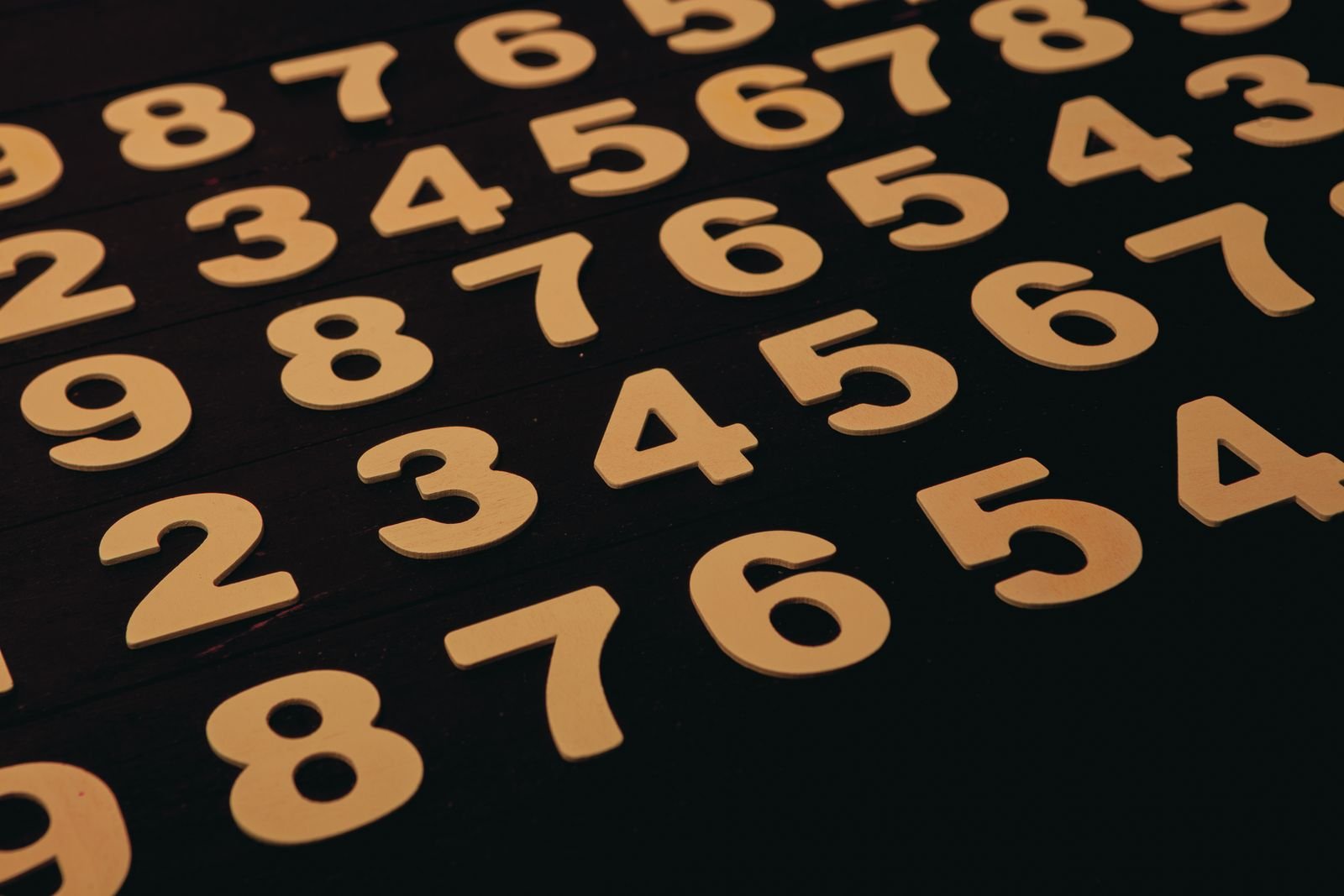 Wooden number digits 1 to 9 arranged on a dark surface